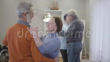 快乐的高加索老人在养老院跳舞。 孤独老人退休后与志愿者在